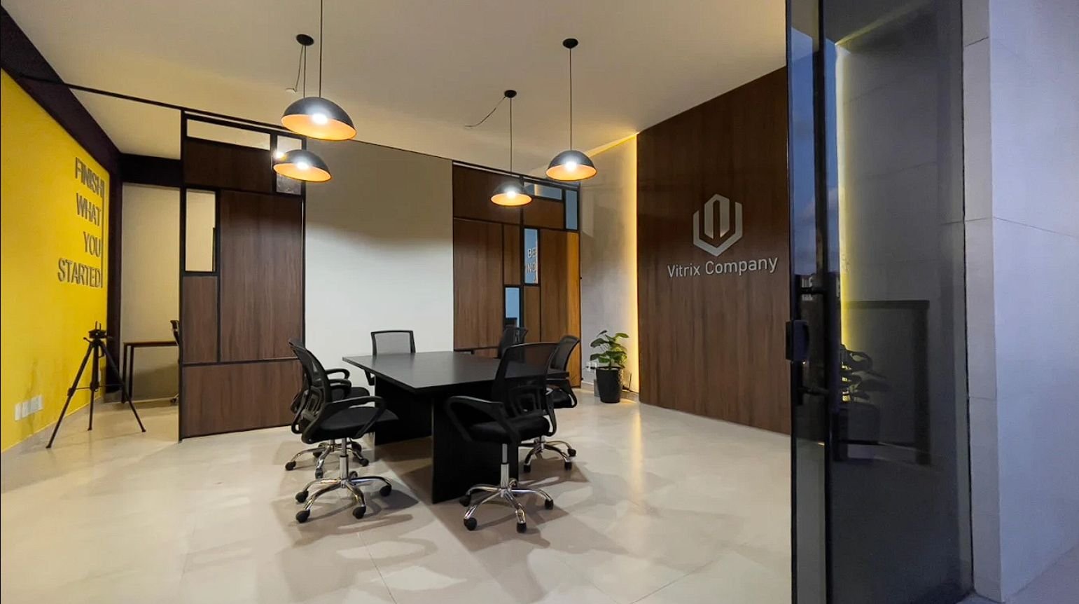 Sala de reunião da sede da Vitrix Company, com a logo na parede de madeira
